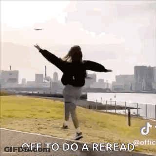 A Woman Is Jumping In The Air With Her Arms Outstretched In Front Of A City Skyline . GIF