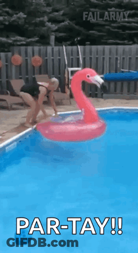 A Woman Is Jumping Into A Swimming Pool With A Flamingo Float . GIF