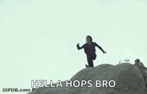 A Woman Is Jumping Off A Rock With The Words `` Hella Hops Bro '' Written Below Her . GIF