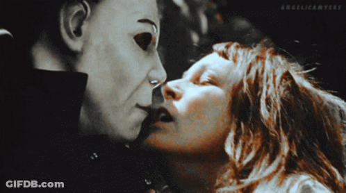 A Woman Is Kissing A Man In A Mask With Angelicanters Written On The Bottom Of The Image GIF