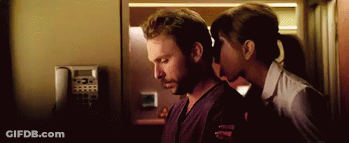 A Woman Is Kissing A Man On The Neck In A Room . GIF
