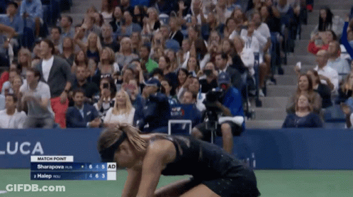 A Woman Is Kneeling Down In Front Of A Crowd At A Us Open Match GIF