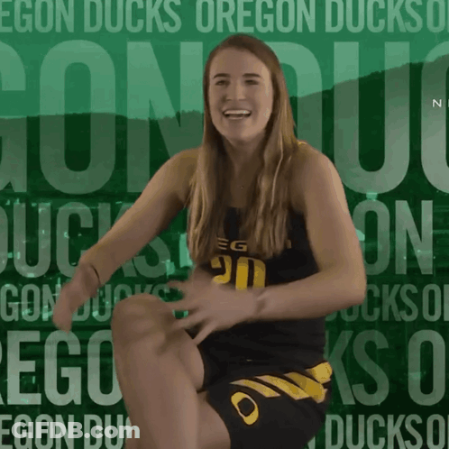 A Woman Is Kneeling Down In Front Of A Green Background That Says Egon Ducks On It GIF