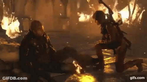 A Woman Is Kneeling Down Next To A Man In A Video Game . GIF