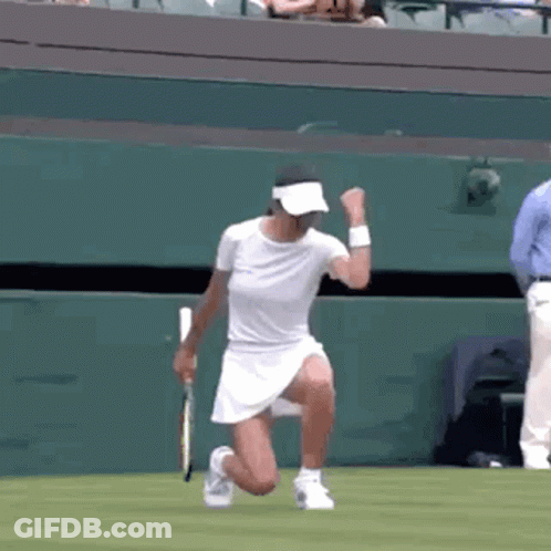 A Woman Is Kneeling Down On A Tennis Court With A Tennis Racket . GIF