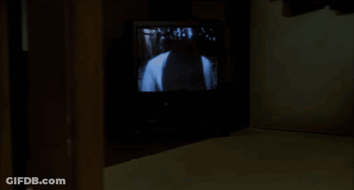 A Woman Is Kneeling On The Floor In Front Of A Tv Screen GIF