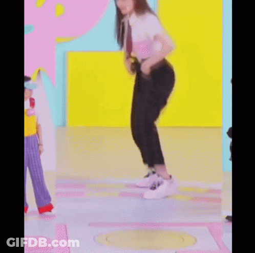 A Woman Is Kneeling On The Floor While Wearing Headphones And Dancing . GIF