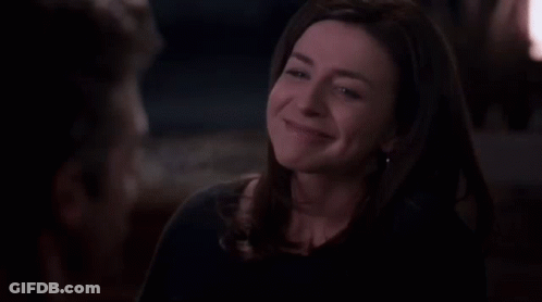 A Woman Is Laughing And Looking Up At Something In The Dark . GIF