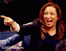 A Woman Is Laughing And Pointing At Something With Her Finger GIF