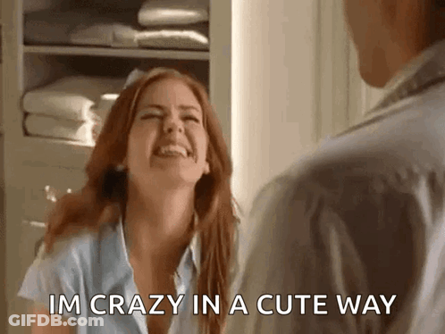A Woman Is Laughing And Talking To A Man In A Room . GIF