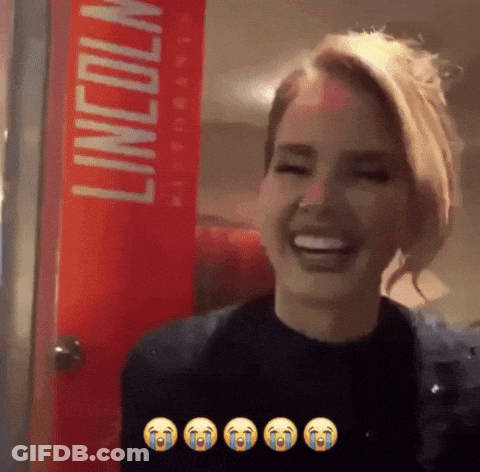 A Woman Is Laughing In Front Of A Red Lincoln Sign GIF