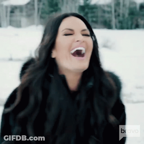 A Woman Is Laughing In The Snow With Bravo On The Bottom GIF
