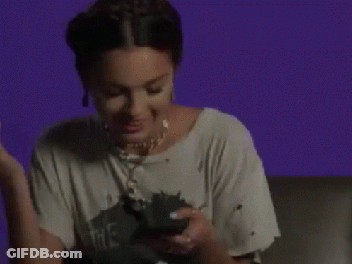 A Woman Is Laughing While Holding A Cell Phone . GIF