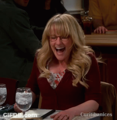 A Woman Is Laughing While Sitting At A Table With Curitibanices Written On It GIF