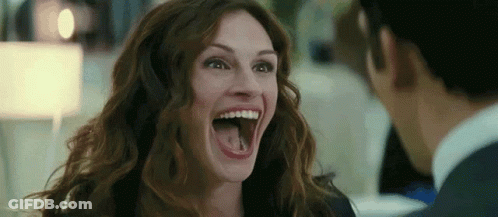 A Woman Is Laughing With Her Mouth Open And Sticking Out Her Tongue . GIF