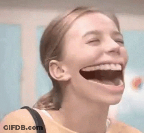 A Woman Is Laughing With Her Mouth Open . GIF