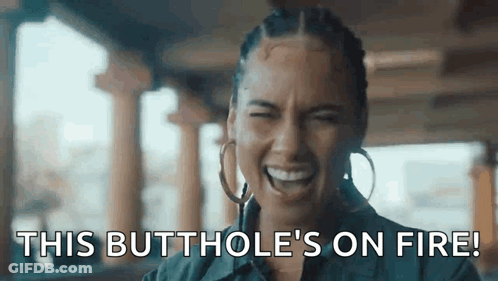 A Woman Is Laughing With The Words `` This Butthole 'S On Fire '' Written On Her Face . GIF
