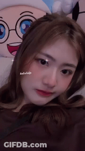 A Woman Is Laying Down With A Stuffed Animal In The Background GIF