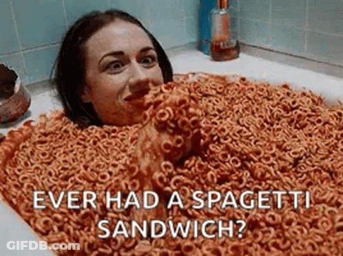 A Woman Is Laying In A Bathtub Filled With Cereal And Spaghetti . GIF