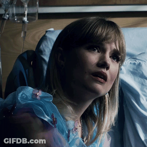 A Woman Is Laying In A Hospital Bed With A Drip In Her Arm GIF