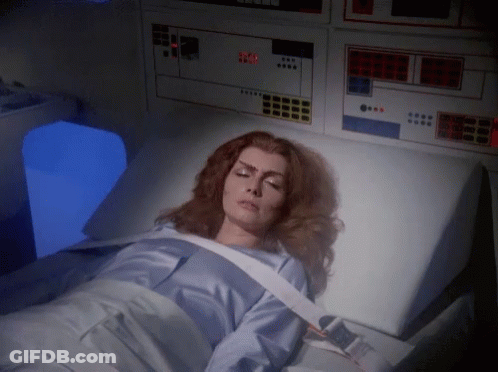 A Woman Is Laying In A Hospital Bed With A Monitor Behind Her That Says ' Emergency Room ' GIF