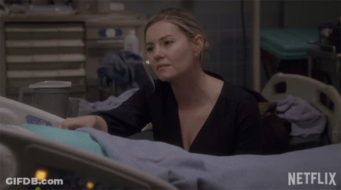 A Woman Is Laying In A Hospital Bed With A Netflix Logo Behind Her GIF