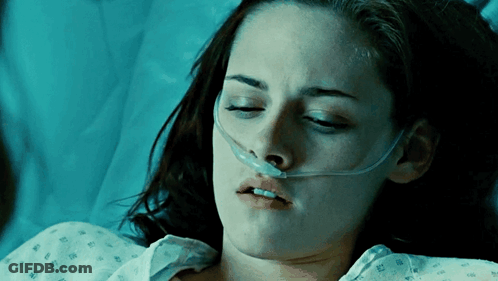 A Woman Is Laying In A Hospital Bed With An Oxygen Mask On Her Nose GIF