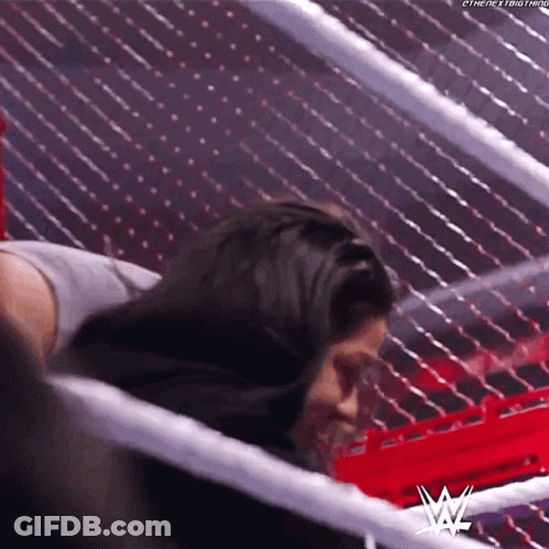 A Woman Is Laying In A Wrestling Ring With Her Head In A Ring . GIF