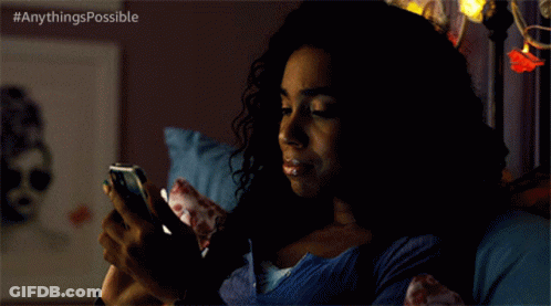 A Woman Is Laying In Bed Looking At Her Phone With The Hashtag Anythings Possible GIF