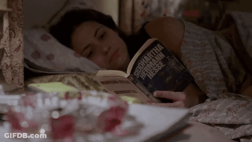 A Woman Is Laying In Bed Reading A Book By Samantha Hermann Hessen GIF