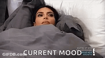 A Woman Is Laying In Bed Under A Blanket With The Words `` Current Mood '' Written On The Bottom . GIF