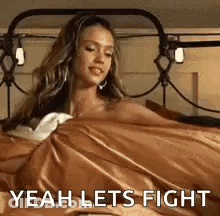 A Woman Is Laying In Bed With A Blanket On Her Head And The Words `` Yeah Lets Fight '' . GIF