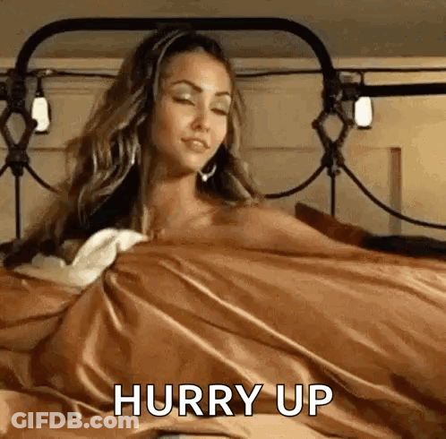 A Woman Is Laying In Bed With A Brown Blanket And A Brown Blanket . GIF