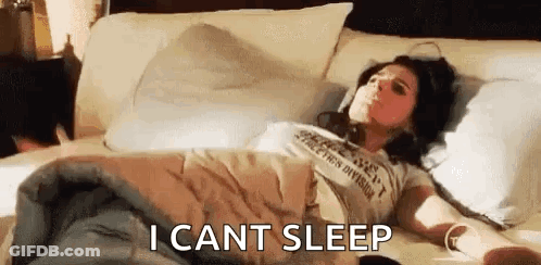 A Woman Is Laying In Bed With Headphones On And The Words `` I Can 'T Sleep '' Written Next To Her . GIF