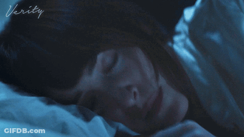 A Woman Is Laying In Bed With The Word Verity On The Bottom GIF