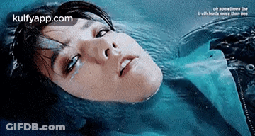 A Woman Is Laying In The Water With Her Eyes Closed And Tears Coming Out Of Her Eyes . GIF