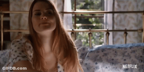 A Woman Is Laying On A Bed With A Netflix Logo On The Bottom GIF