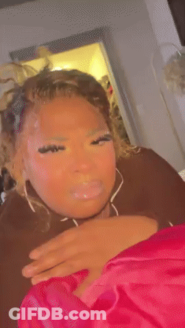 A Woman Is Laying On A Bed With Her Eyes Closed And Making A Funny Face . GIF