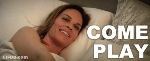 A Woman Is Laying On A Bed With The Words Come Play Behind Her GIF