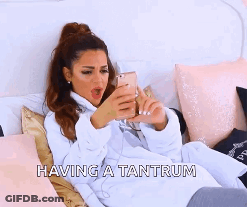 A Woman Is Laying On A Bed With The Words Having A Tantrum Written Above Her . GIF