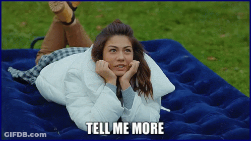 A Woman Is Laying On A Blue Mattress With The Words Tell Me More Written Below Her GIF