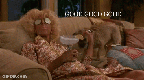 A Woman Is Laying On A Couch Holding A Martini And Smoking A Cigarette With The Words Good Good Good Above Her GIF