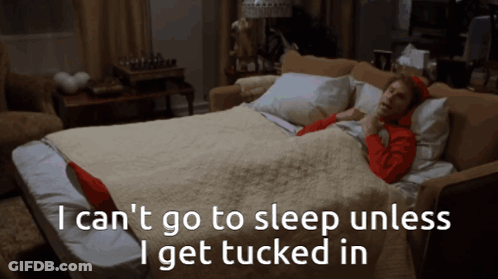 A Woman Is Laying On A Couch With The Words " I Can 'T Go To Sleep Unless I Get Tucked In " GIF