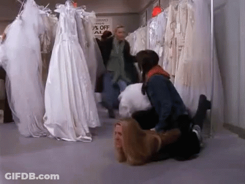 A Woman Is Laying On A Man 'S Lap In A Bridal Shop . GIF