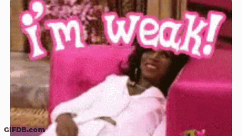 A Woman Is Laying On A Pink Couch With A Sign That Says `` I 'M Weak '' On Her Head . GIF