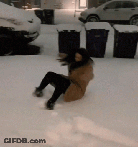 A Woman Is Laying On Her Back In The Snow In A Parking Lot GIF