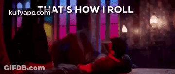 A Woman Is Laying On Her Stomach On A Bed In A Dark Room . GIF