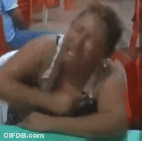 A Woman Is Laying On Her Stomach With Her Head On A Table . GIF