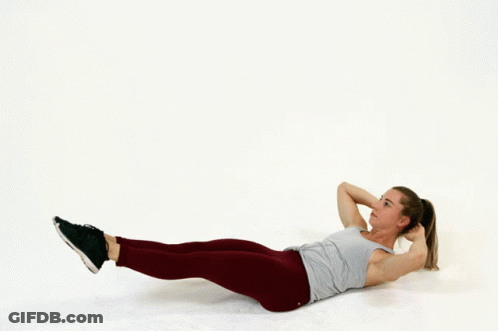A Woman Is Laying On The Floor Doing A Crunch Exercise GIF