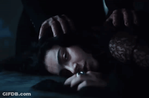 A Woman Is Laying On The Floor With Her Hands On Her Head . GIF